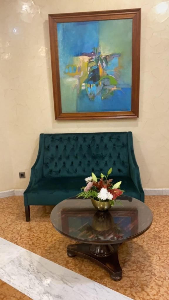 hotel area with pretty chair and painting plus table with flowers