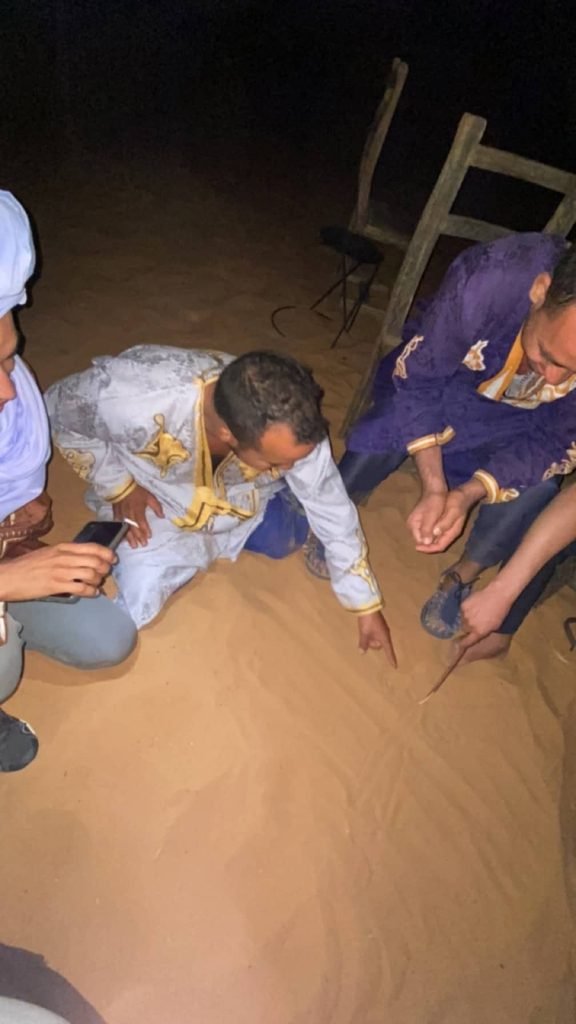 local moroccans playing games in the sand