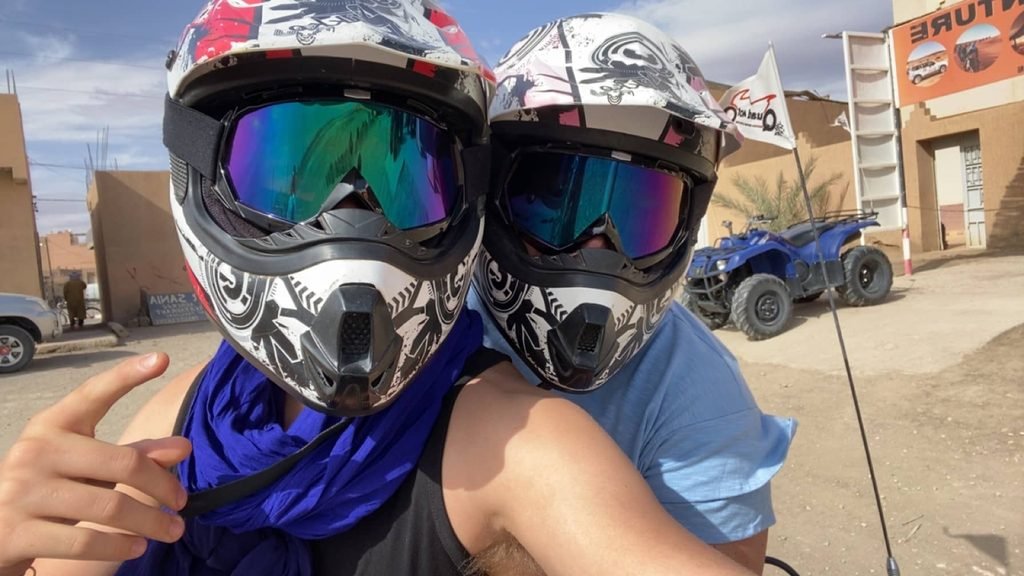 two people on a quad bike in helmets