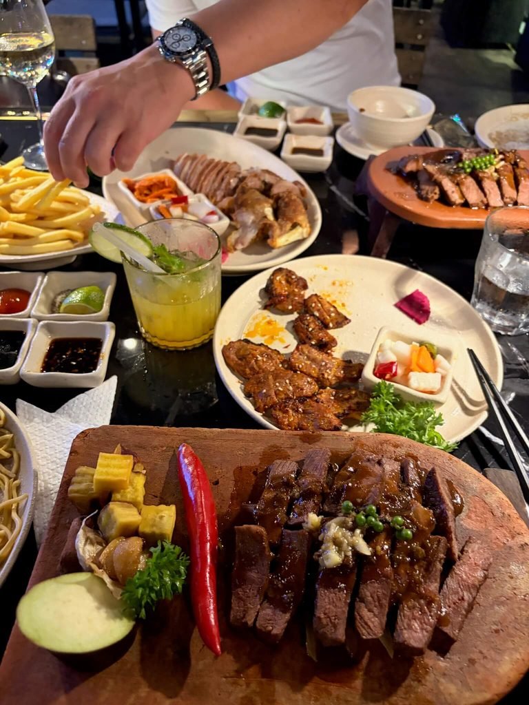 loads of plates of vietnamese food and hand reaching for them