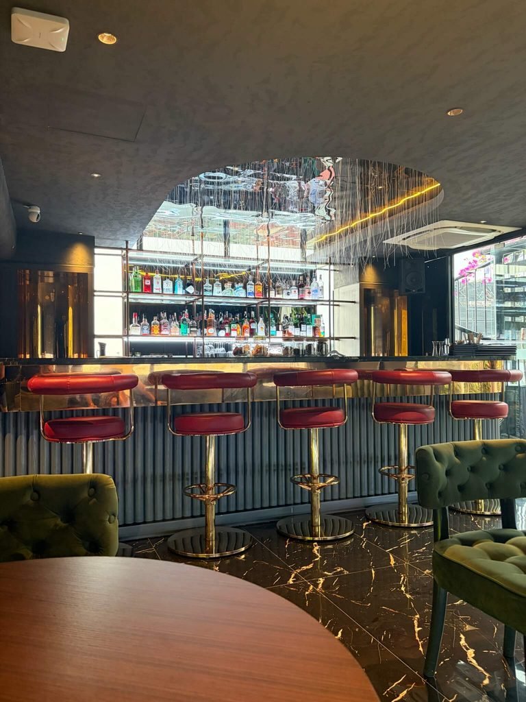 bar stools and bar with drinks behind