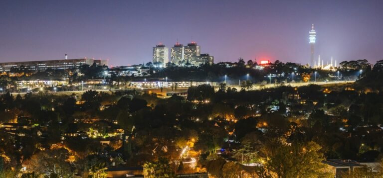 Panoramic view of the Johannesburg city skyline at night featuring illuminated skyscrapers and city lights, South Africa.
